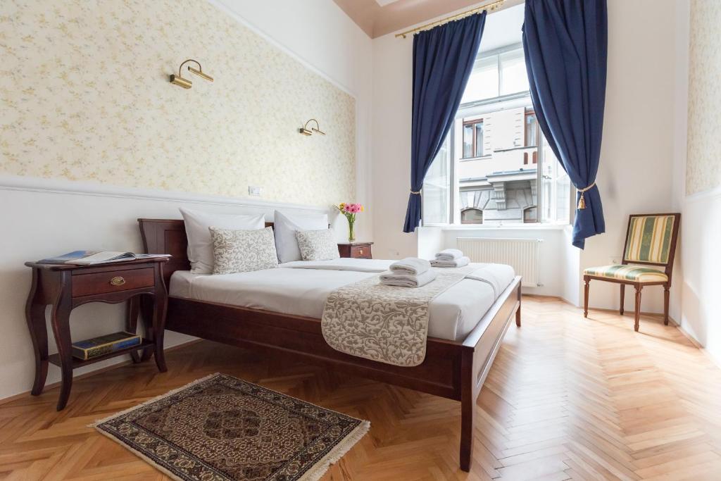 a bedroom with a bed and a table and a window at Barbo Palace Apartments and Rooms in Ljubljana