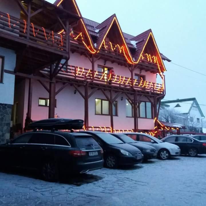a group of cars parked in front of a building at Pensiunea Valcinet in Borşa