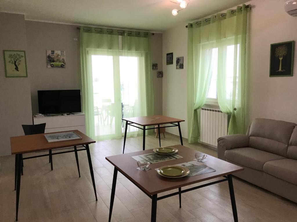 ein Wohnzimmer mit 2 Tischen und einem Sofa in der Unterkunft B&B Oleum in Terlizzi