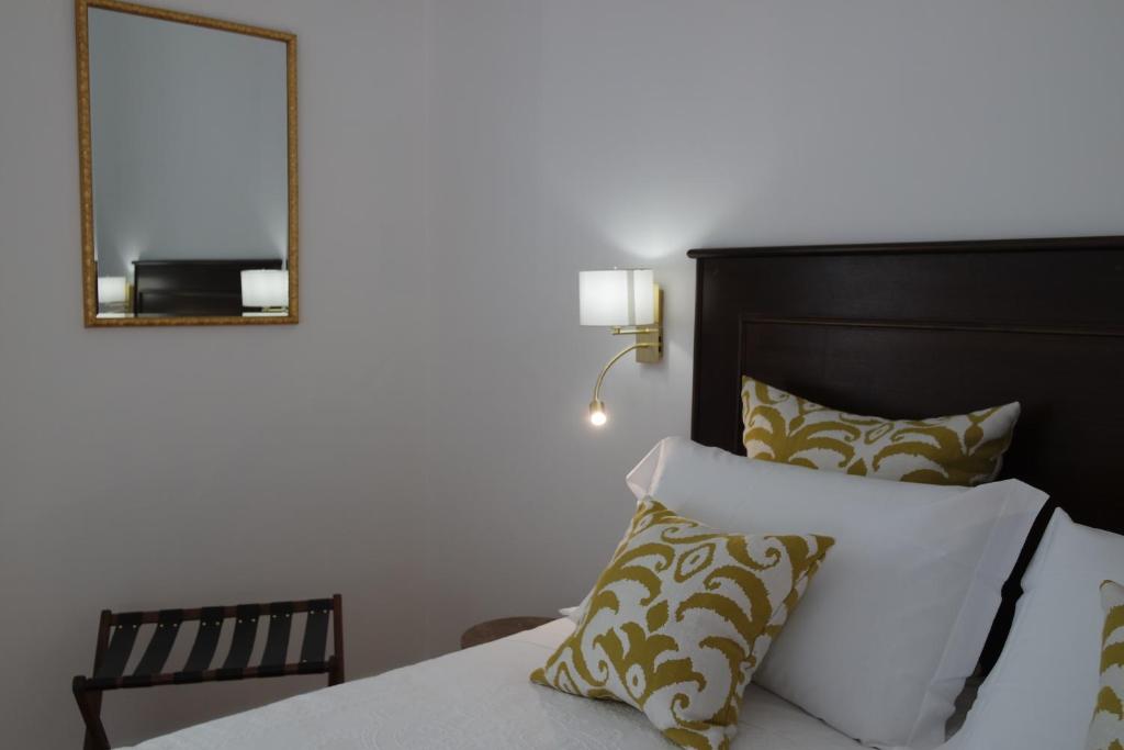 una camera da letto con letto, specchio e cuscini di Hotel Livio a Brescia