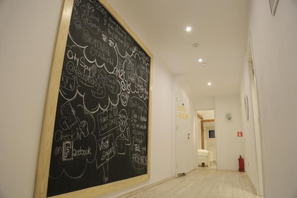 a chalkboard with writing on a wall in a hallway at Bread&Breakfast in Bucharest