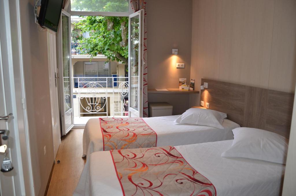 Postel nebo postele na pokoji v ubytování Brit Hotel Confort Le Revest Sainte-Maxime
