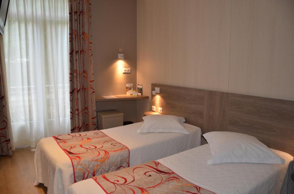 Postel nebo postele na pokoji v ubytování Brit Hotel Confort Le Revest Sainte-Maxime