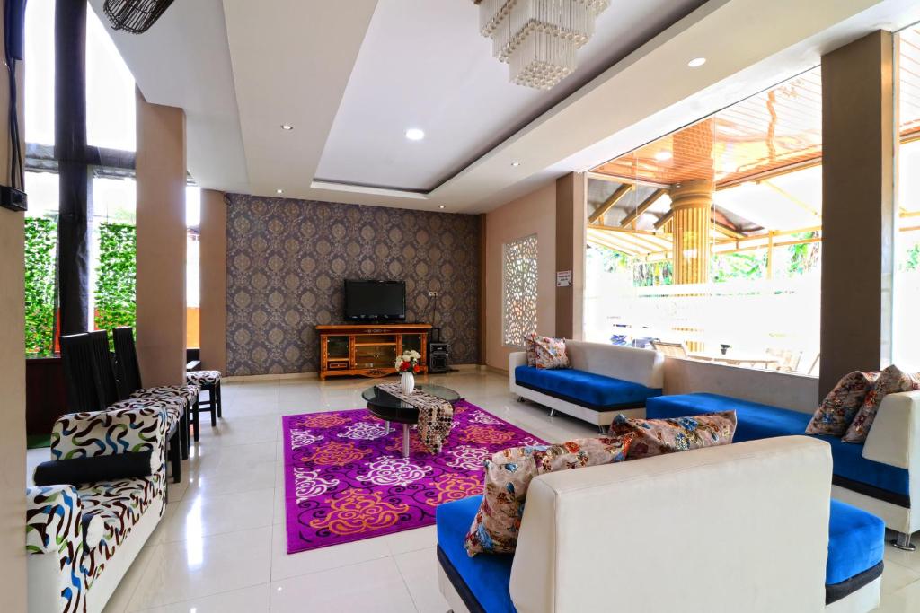 a living room with couches and a tv at Ombey Guest House in Bogor
