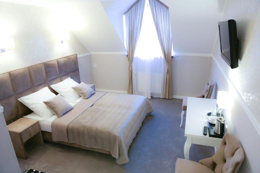 a bedroom with a large bed and a window at Hotel Bellis in Lublin