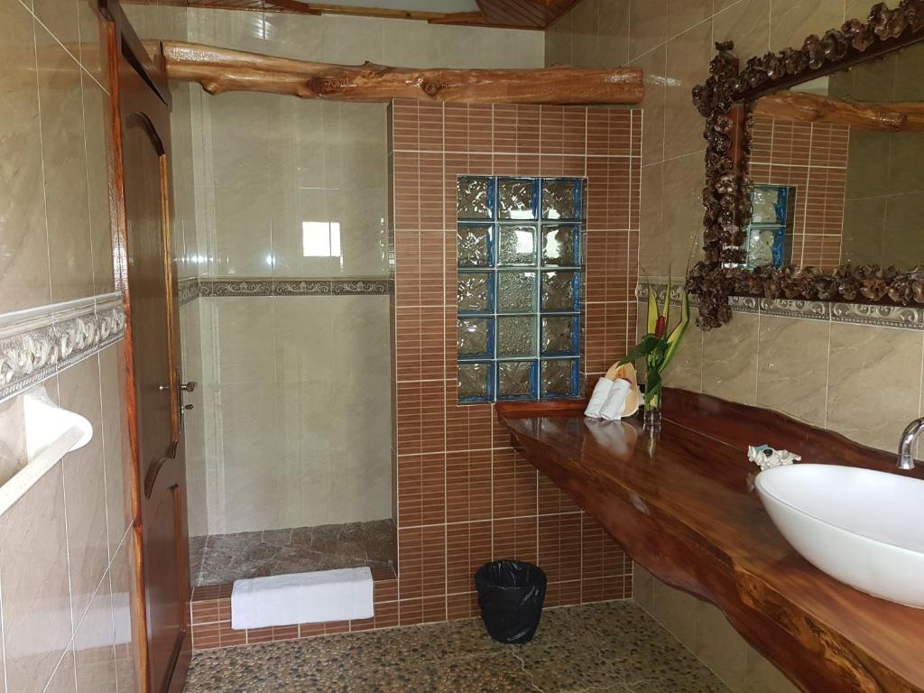 a bathroom with a sink and a shower with a mirror at Elje Villa in La Digue