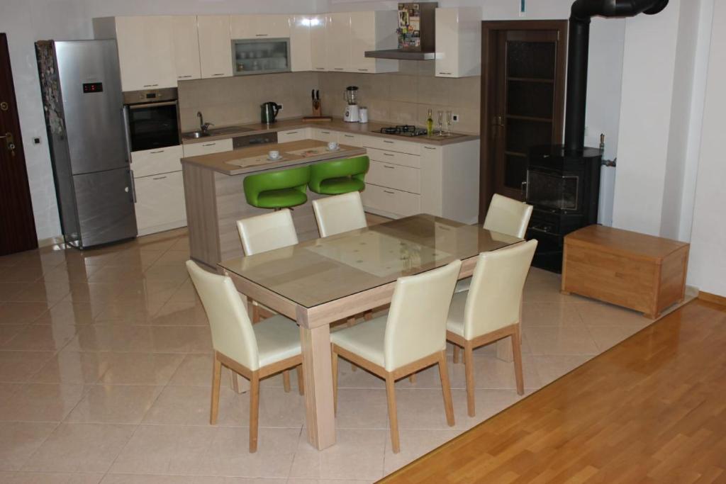 - une cuisine avec une table en bois et des chaises blanches dans l'établissement Apartment Time out, à Kaštela