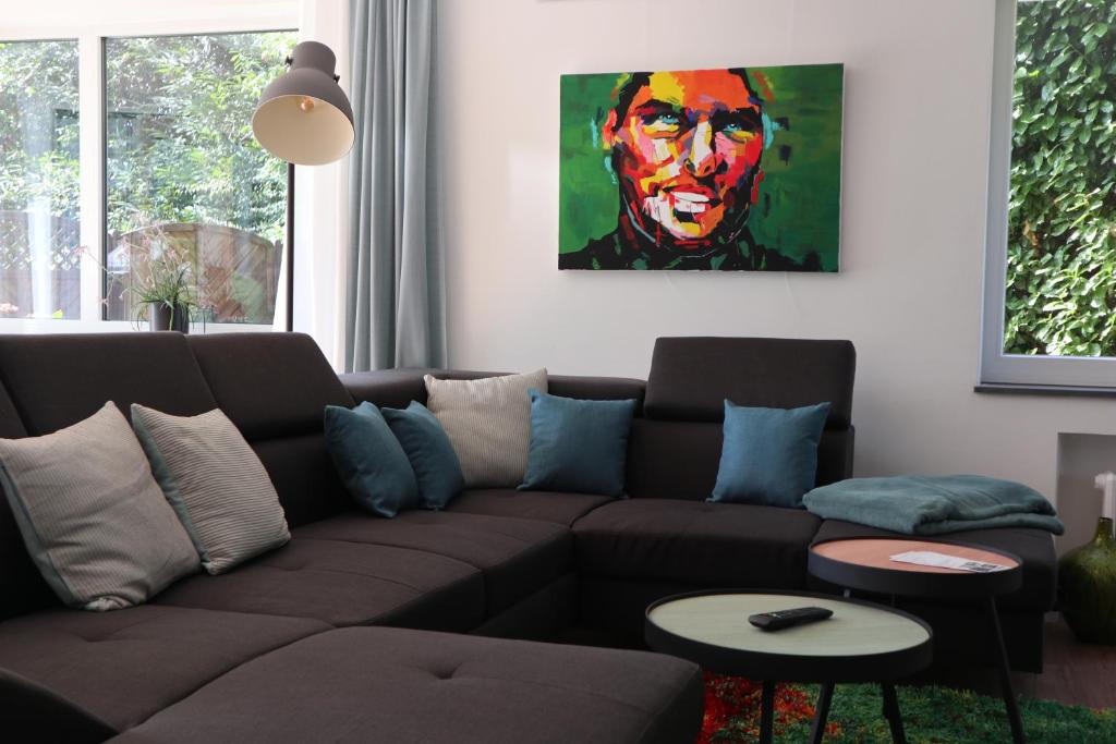 een woonkamer met een bruine bank en een schilderij bij galerie 65 in Nettetal