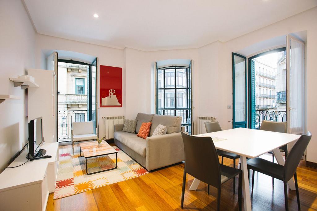 sala de estar con mesa y sofá en Apartamentos San Marcial 28, en San Sebastián