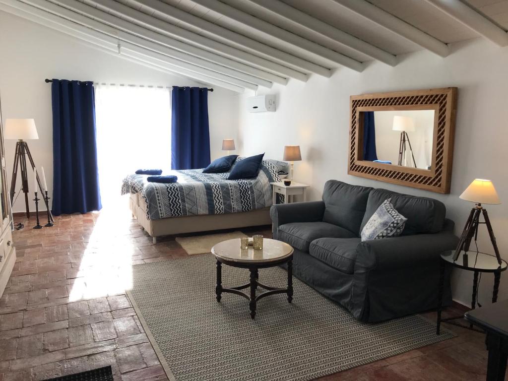 a living room with a couch and a bed at Studio Colina in Tavira