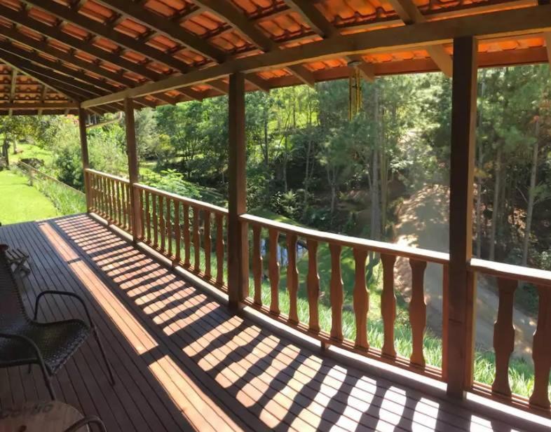 a wooden deck with a bench on a porch at Pousada Bergen Hütten in Rio Fortuna