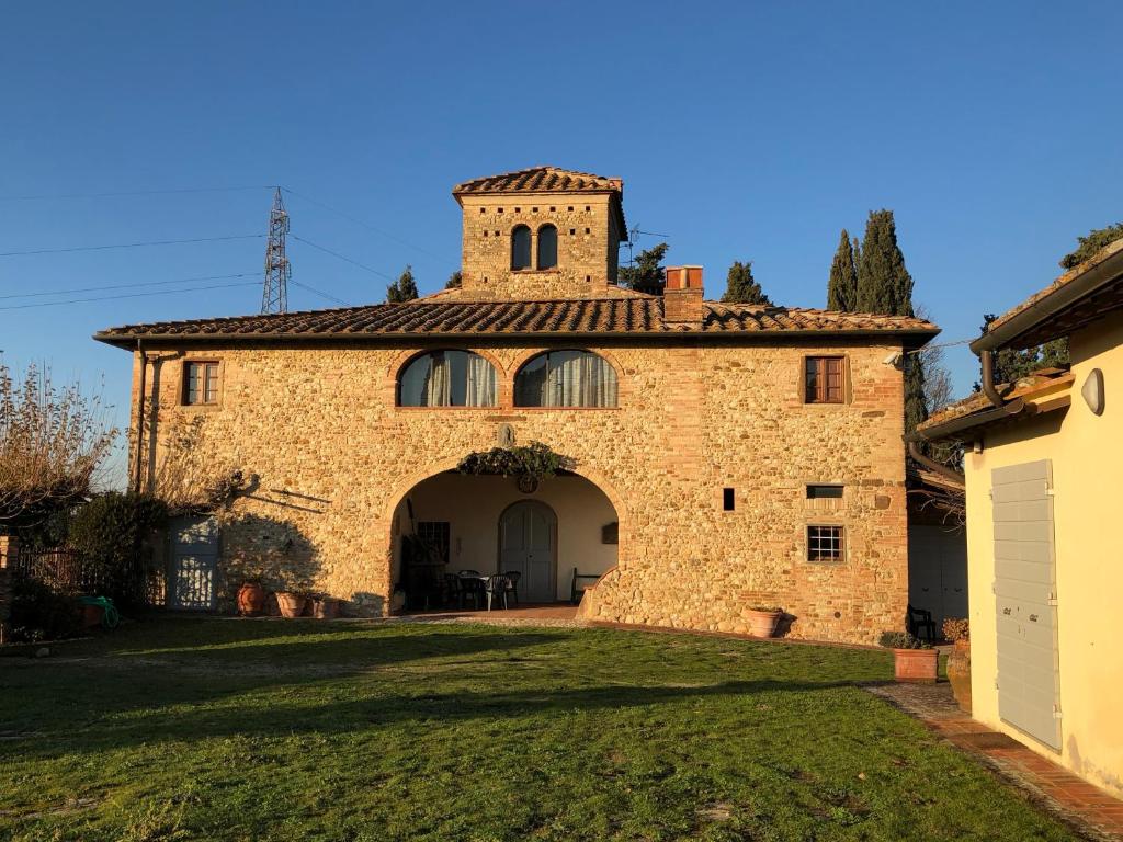 an external view of a large brick building with a tower at Casa di Romano, Al Tramonto in Marcialla