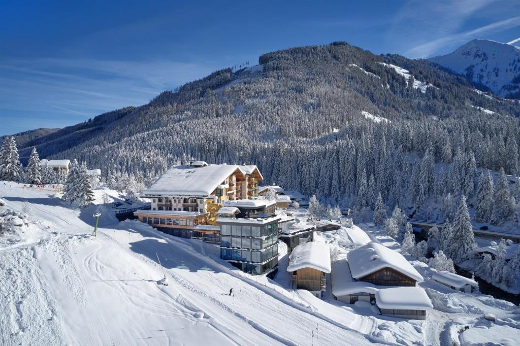 a ski lodge in the snow with a mountain at Almhof Family und Wellness Resort in Gerlos