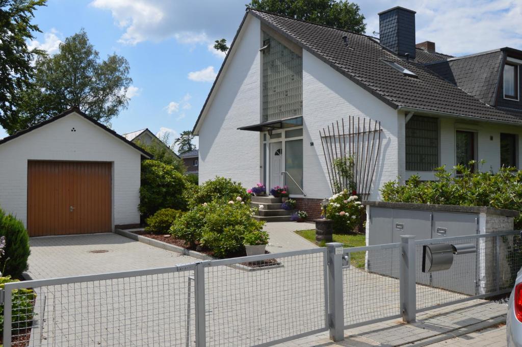 una casa blanca con una valla delante en Ferienwohnung-Osten, en Schenefeld