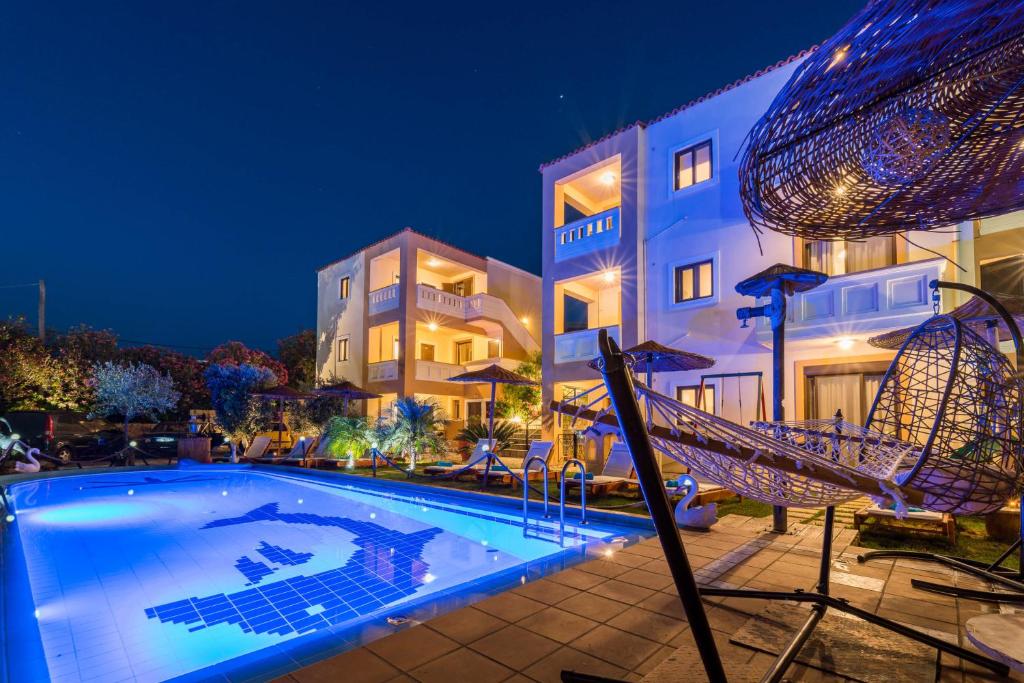 Villa Gereoudis Apartments with Sea View & Pool في كوليمفاري: مسبح امام مبنى في الليل