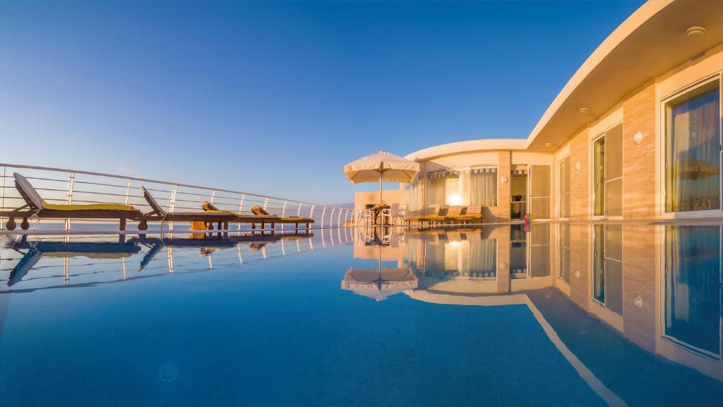 a hotel with a swimming pool next to a building at Villa Watersedge in Marsaskala