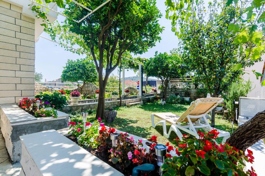 a garden with a chair and flowers at Apartment Antea in Mlini