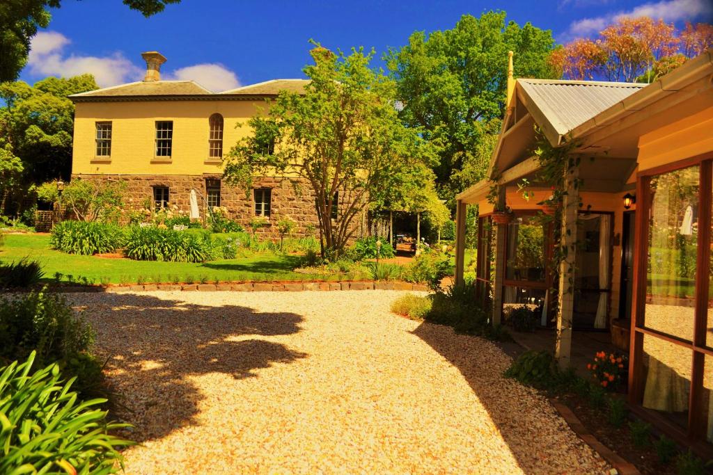 a house with a gravel driveway next to a house at Bindley House B&B Cottage in Kilmore