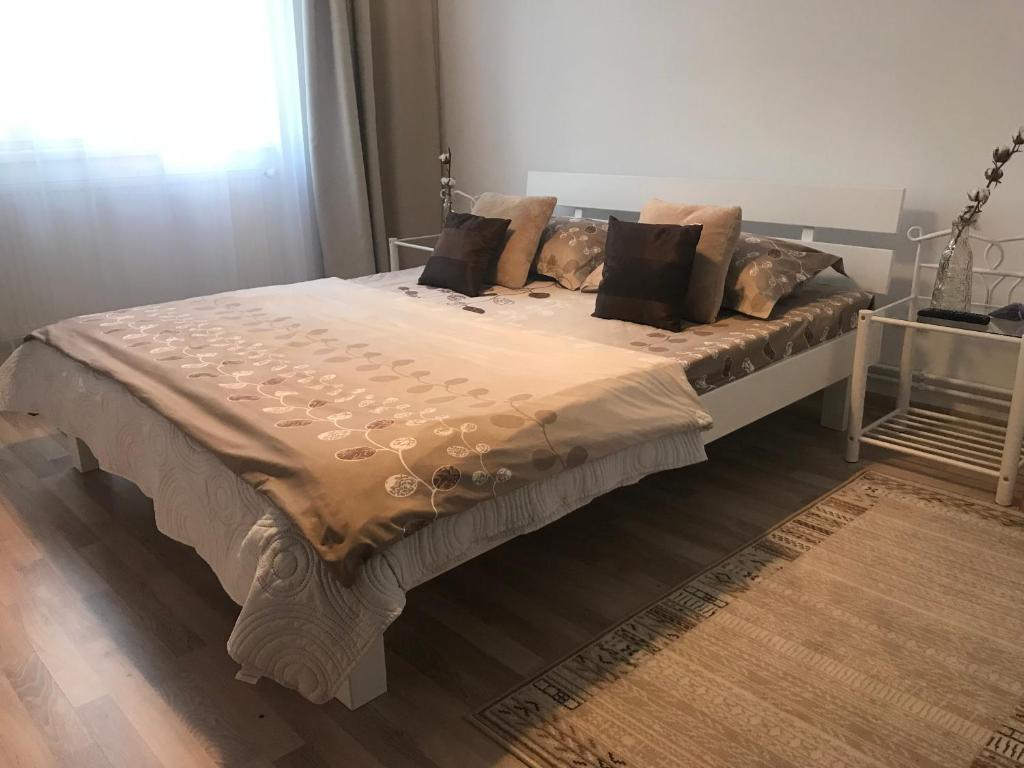a bed with pillows and a blanket on it at Joy Apartment in Timişoara