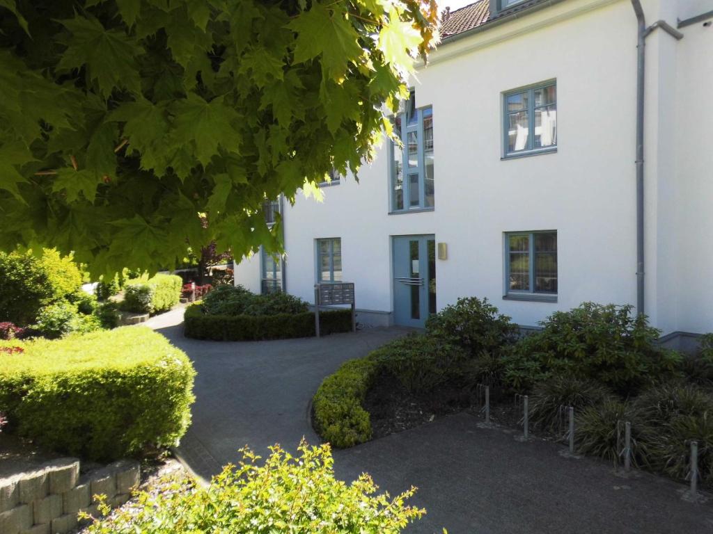 a white house with a courtyard in front of it at 54 Appartement Residenz Bellevue U in Zinnowitz