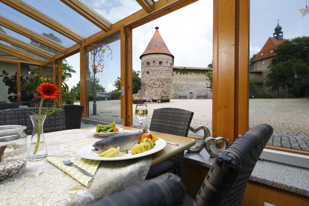 einen Tisch mit einem Teller Essen und ein Schloss in der Unterkunft Gasthof Zur Burg in Hohenberg an der Eger