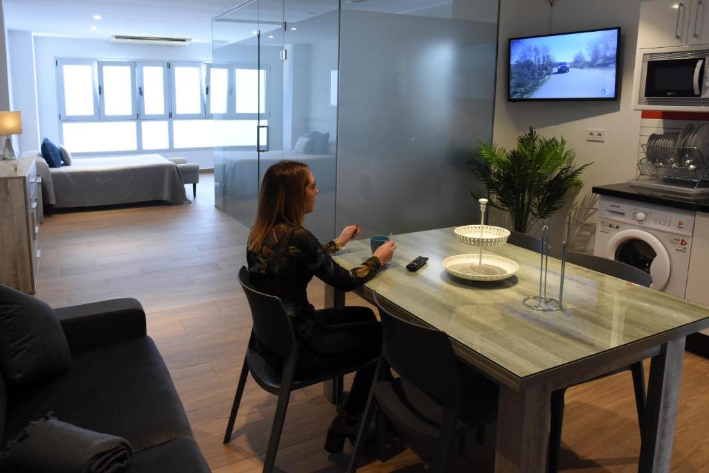 a woman sitting at a table in a living room at Ardales Loft in Ardales