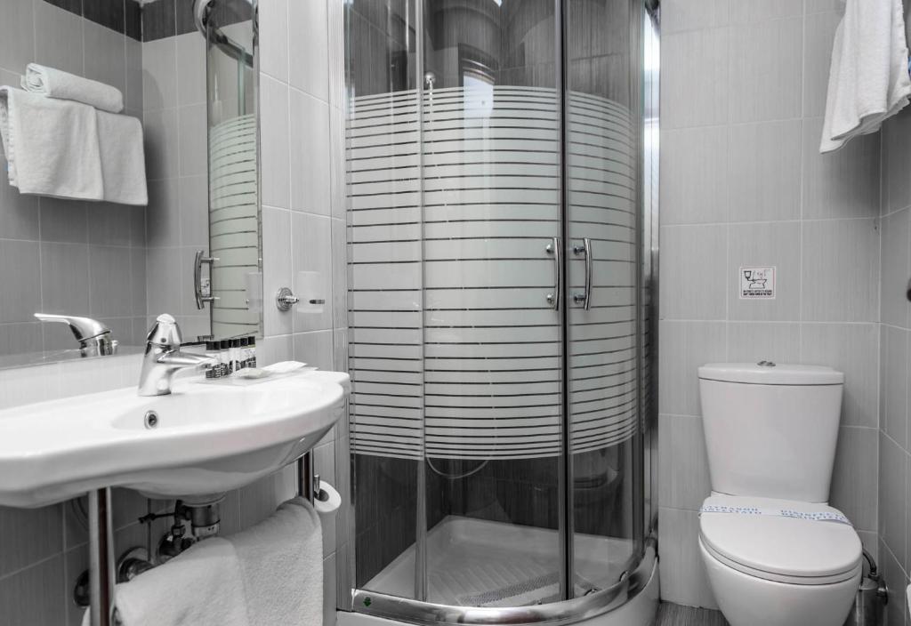 a bathroom with a shower and a toilet and a sink at Agamemnon Hotel in Nafplio