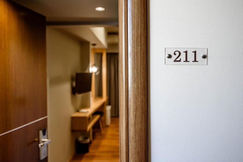 a door to a room with a television and a hallway at Agamemnon Hotel in Nafplio