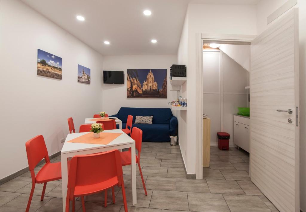ein Wohnzimmer mit einem Tisch und einem blauen Sofa in der Unterkunft Casa Rossini in Ragusa