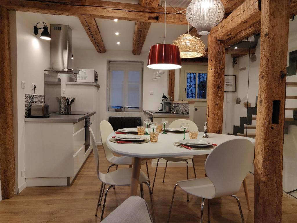 a kitchen and dining room with a white table and chairs at Elsass Design Hygge in Eguisheim