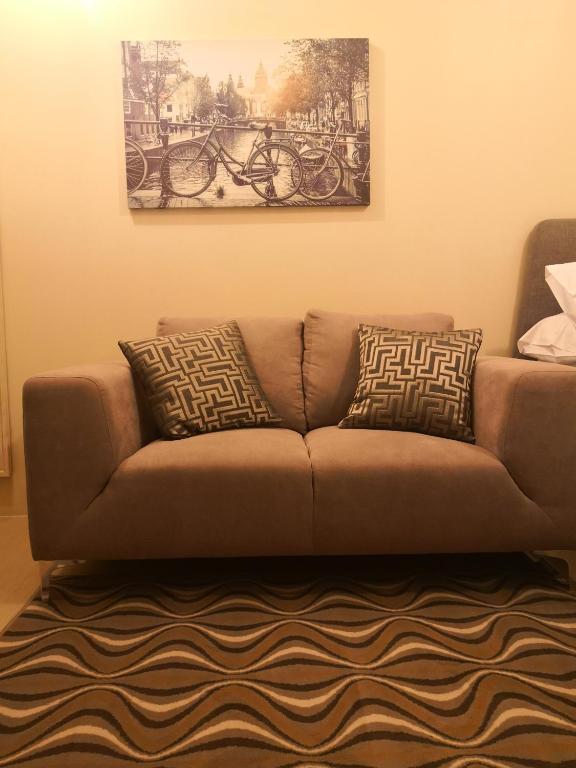 a brown couch with two pillows in a living room at Cagayan de oro condo rentals 21 in Cagayan de Oro