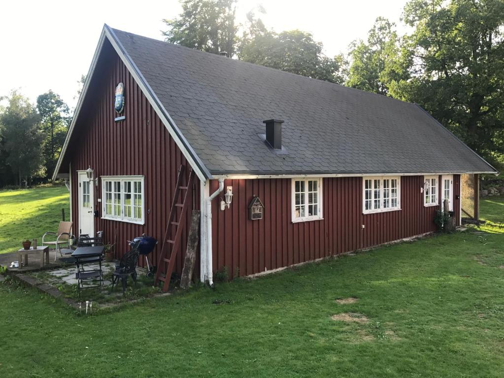 une grange rouge avec une échelle et un grill dans l'établissement Sävekulla 207 "Brygghuset", à Älvsered