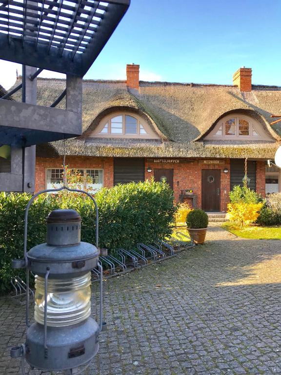 a brick house with a fountain in front of it at "Netzboden" by Ferienhaus Strandgut in Born