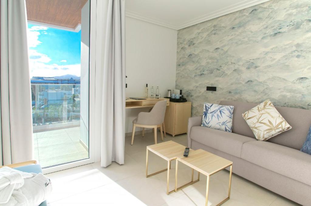 a living room with a couch and a table at Hotel Lava Beach in Puerto del Carmen
