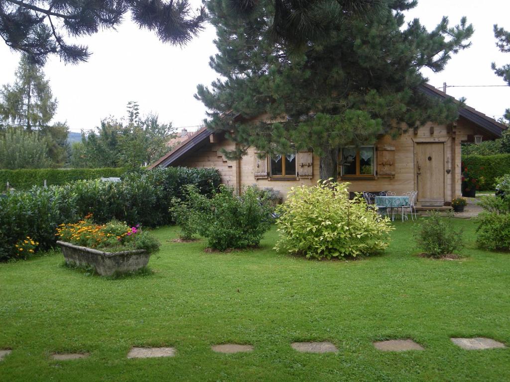 a house with a yard with flowers and a house at Chalet de campagne in Sancey-le-Grand