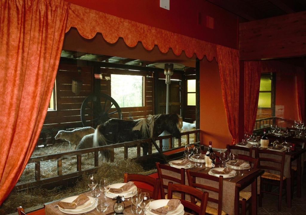 a dining room with a horse standing in a window at Tenuta del Vecchio Mulino in Motta deʼConti