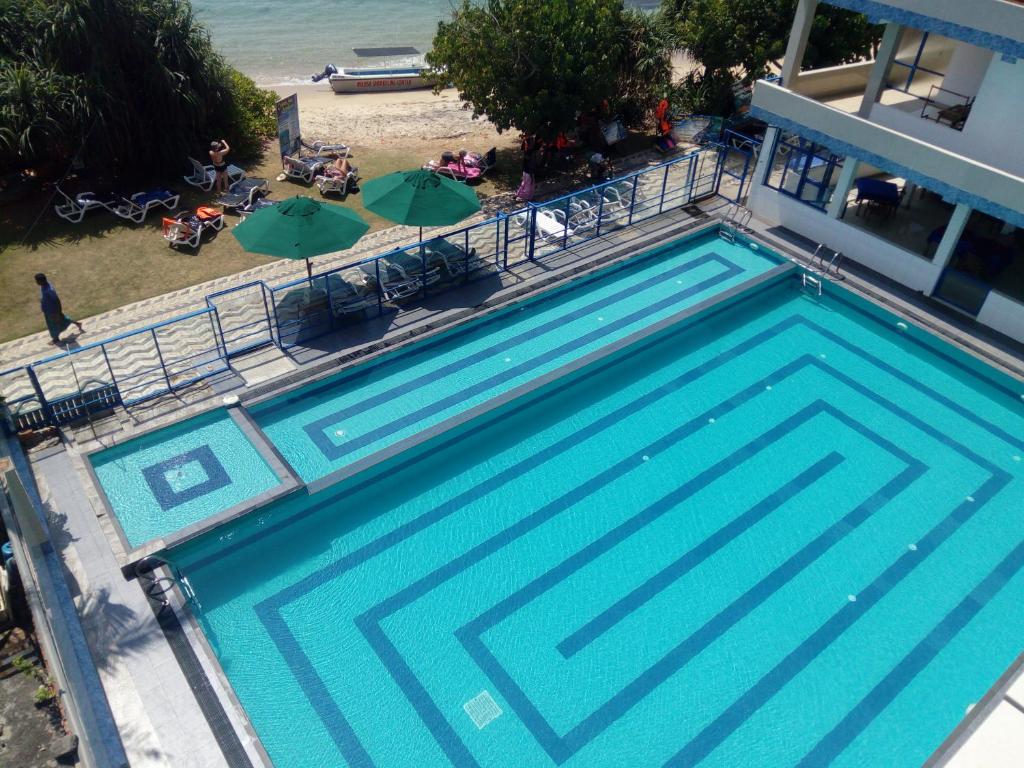 an overhead view of a swimming pool next to a beach at Paradise Beach Resort & Diving school in Mirissa
