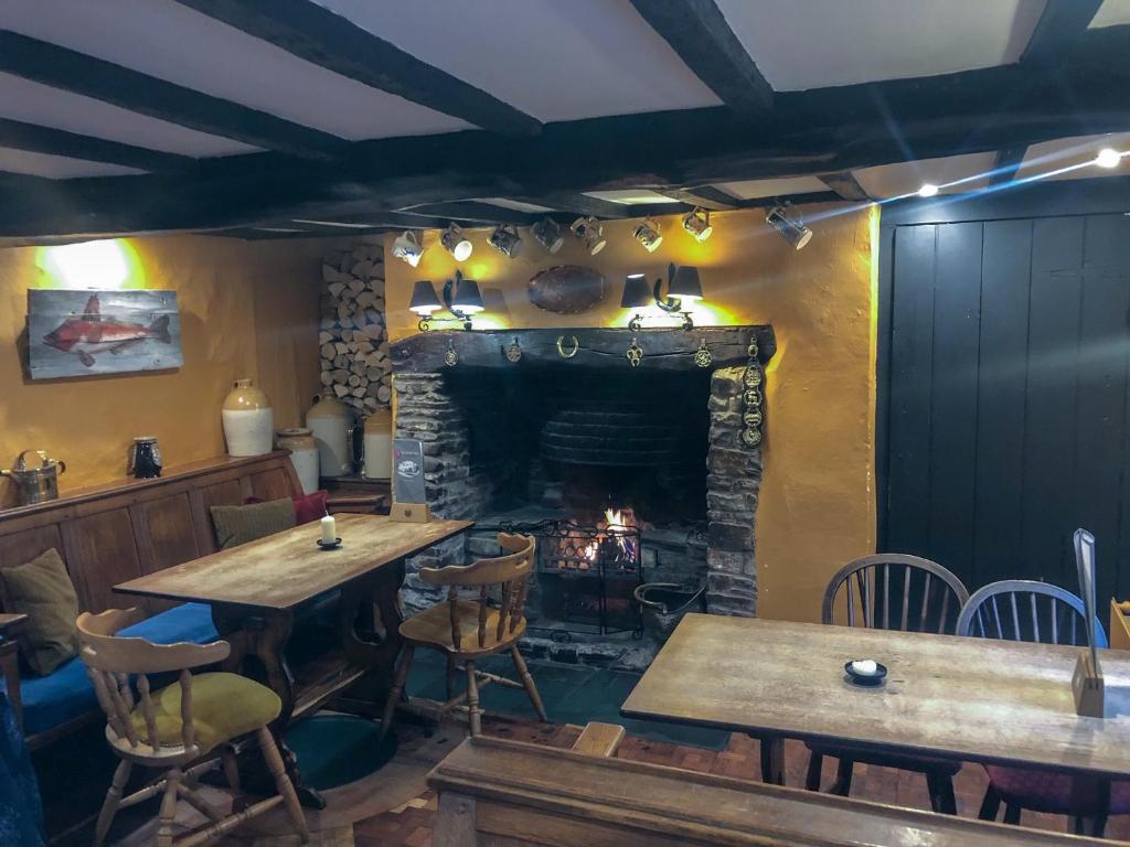 a restaurant with two tables and a fireplace at The Hoops Inn & Country Hotel in Bideford