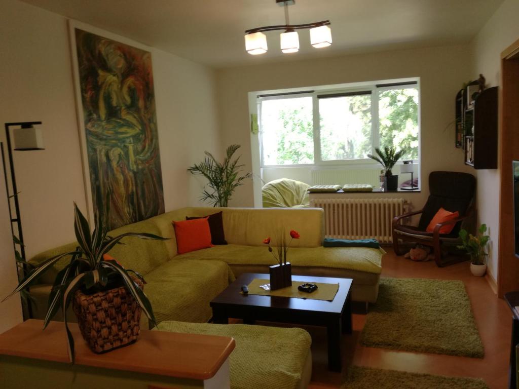 a living room with a yellow couch and a table at Green Apartment in Odorheiu Secuiesc