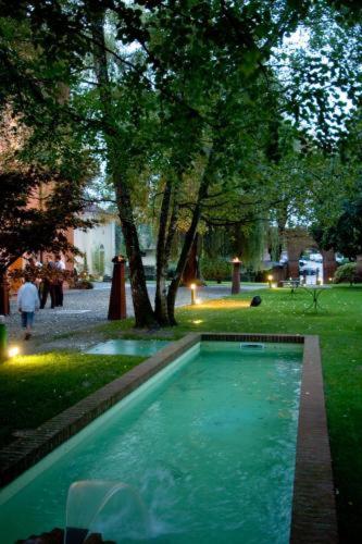 basen wodny w parku z drzewami w obiekcie Relais Del Castello Di Oviglio w mieście Oviglio