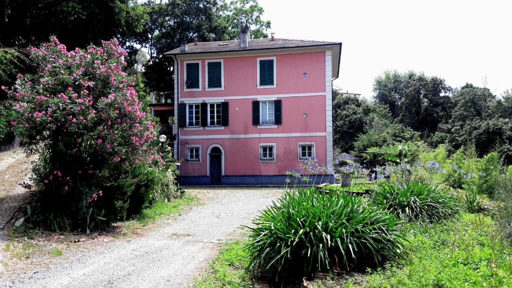 una casa rosa en medio de un camino de tierra en The italian riviera, en San Salvatore