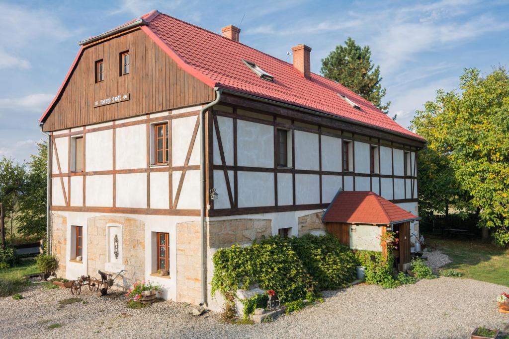 een oud huis met een rood dak en een tuin bij Holiday Home Usedlost Nový Svět in Růžová