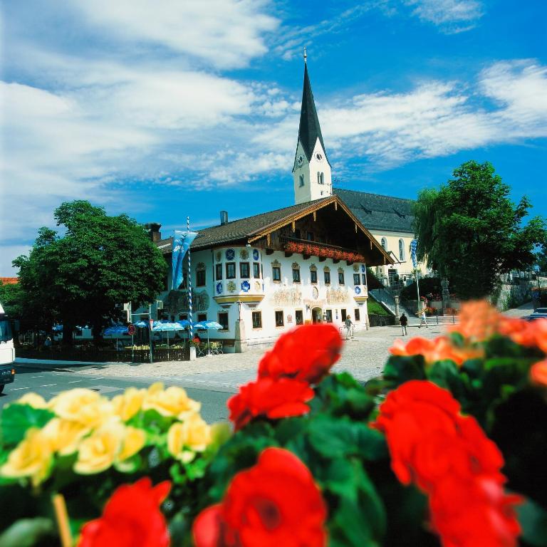 a building with a steeple with a bunch of flowers at Gasthof Alter Wirt in Bernau am Chiemsee