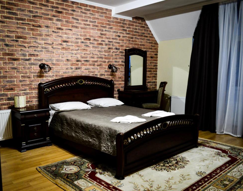 Un dormitorio con una cama y una pared de ladrillo. en Recreation Complex Sunny Resort, en Polyana