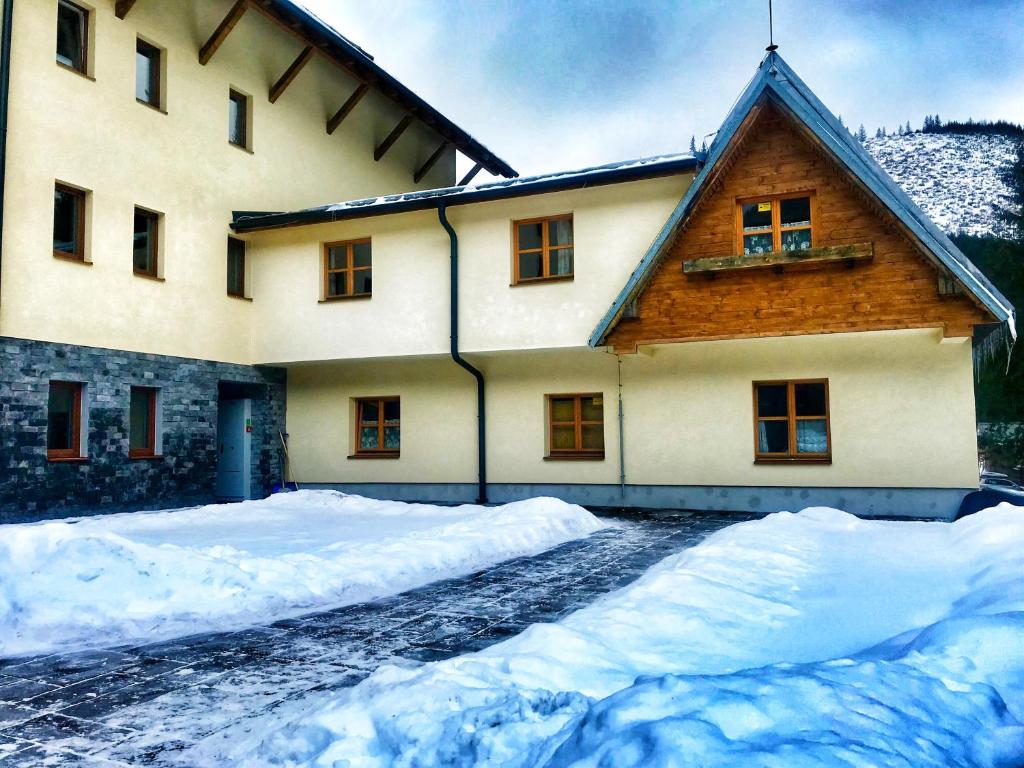 a house with snow piled up in front of it at Apartman Lúčky-Rea in Belá