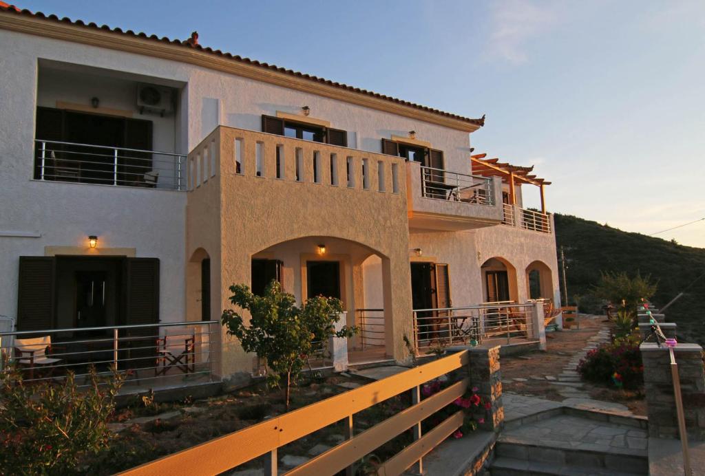 uma casa grande com uma cerca em frente em Anemi Apartments em Armenistís