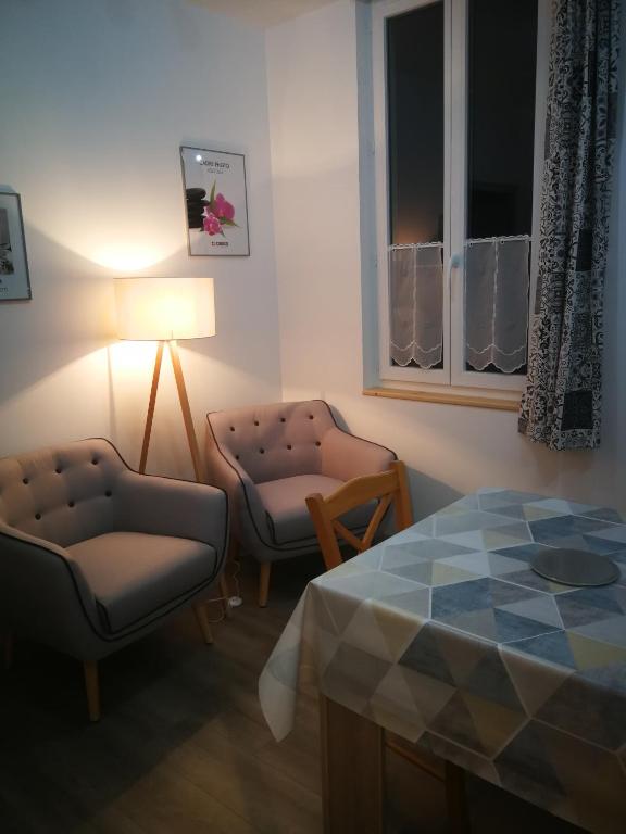 sala de estar con mesa, sillas y lámpara en lupin, en Rochefort
