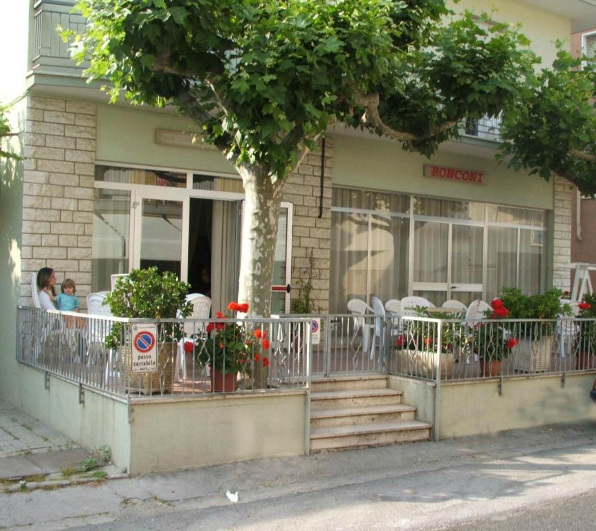 a building with tables and chairs on a balcony at Hotel Ronconi in Rimini