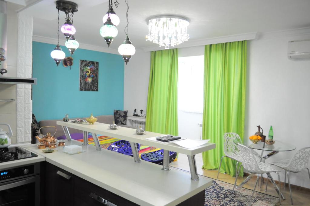eine Küche mit einer weißen Theke und grünen Vorhängen in der Unterkunft Baku Seafront Apartment in Baku