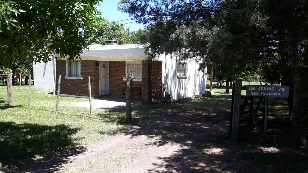 una pequeña casa de ladrillo con un cartel delante en Casa Don Francisco, en Termas del Daymán